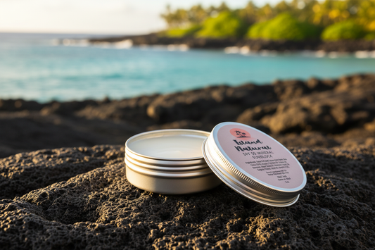 Island Natural SPF 30 Mineral Sunblock tin open on a sun-drenched volcanic rock in Maui with turquoise ocean in the background
