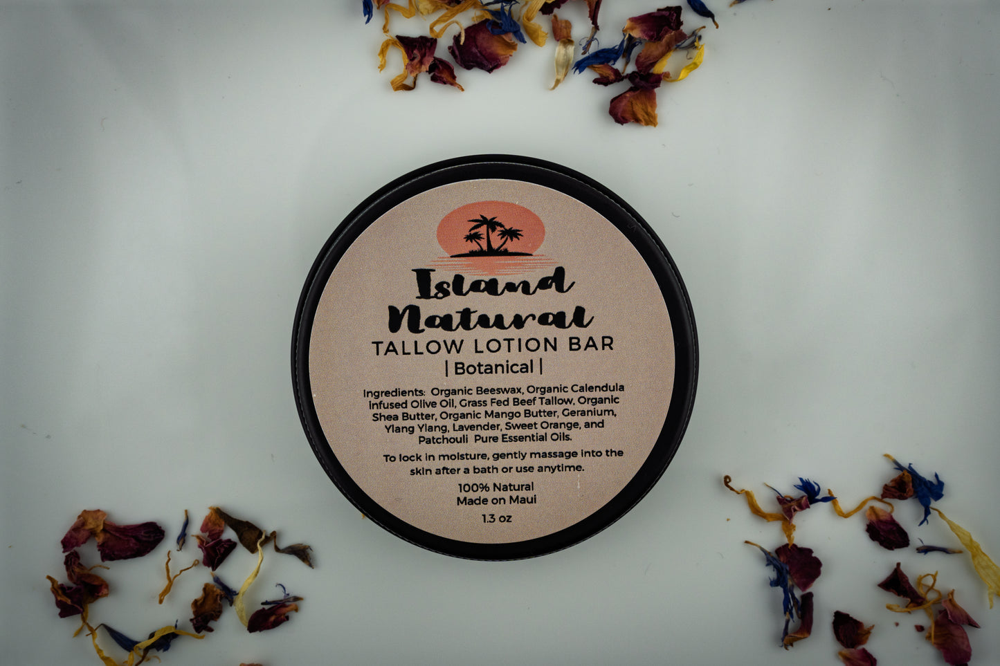 Island Natural Skincare Tallow Lotion Bar on a white background with dried botanicals around it