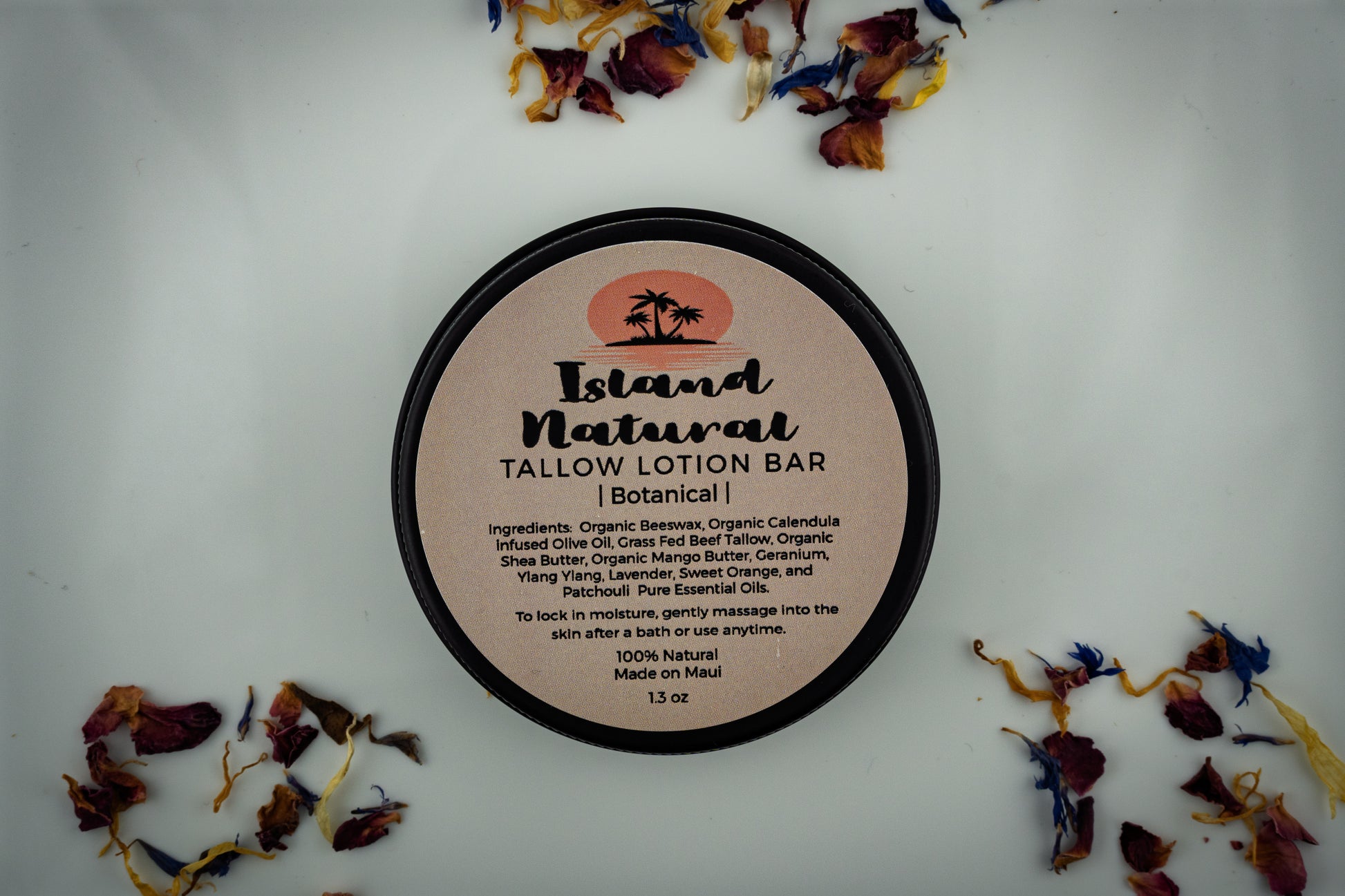 Island Natural Skincare Tallow Lotion Bar on a white background with dried botanicals around it