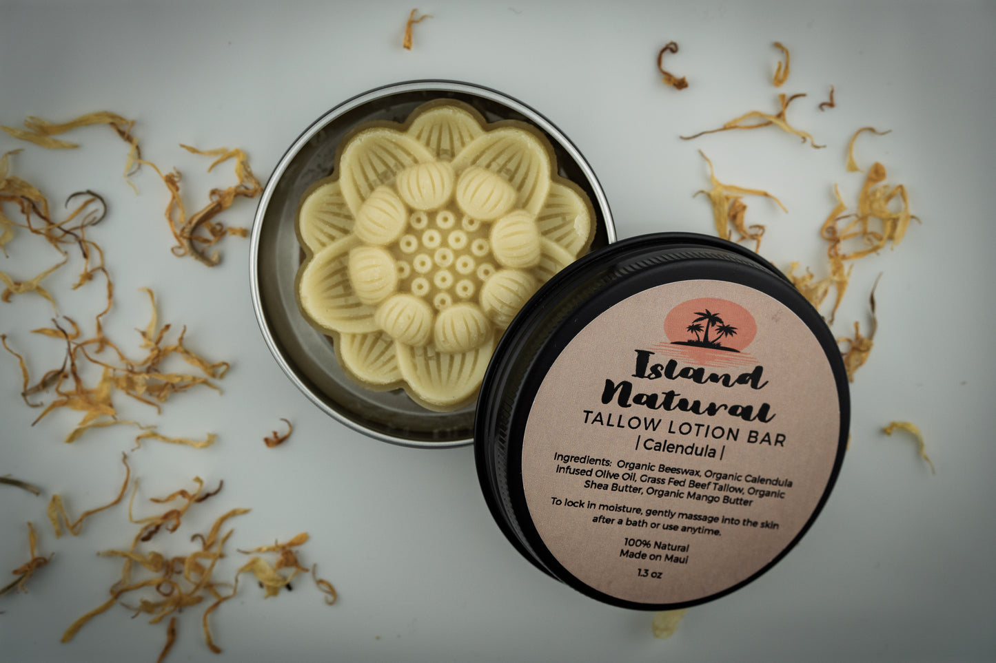 Island Natural Skincare tallow lotion bar with a decorative lid on a white background with dried flowers.