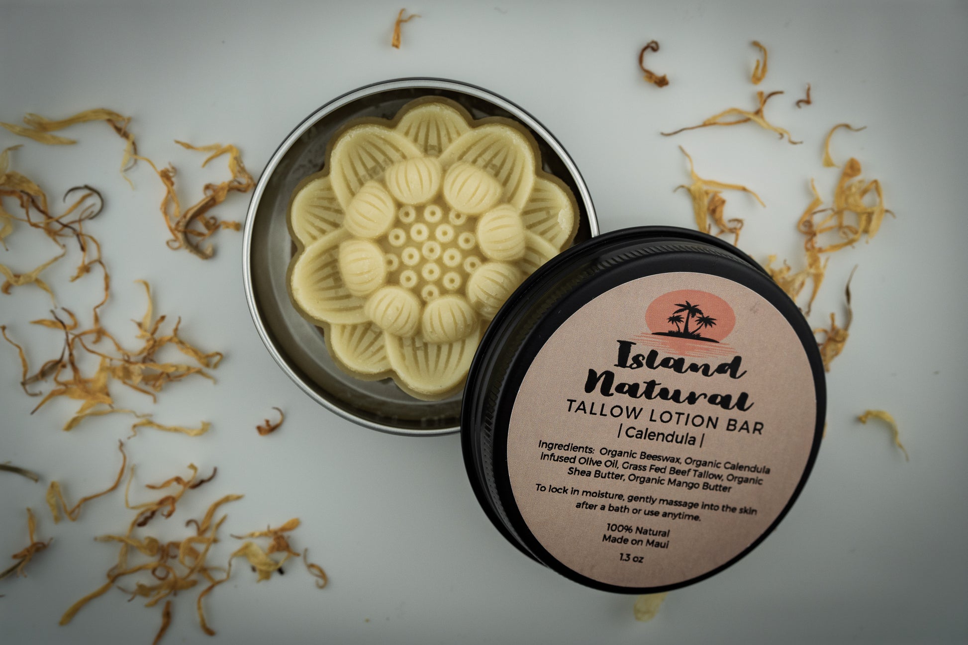 Island Natural Skincare tallow lotion bar with a decorative lid on a white background with dried flowers.