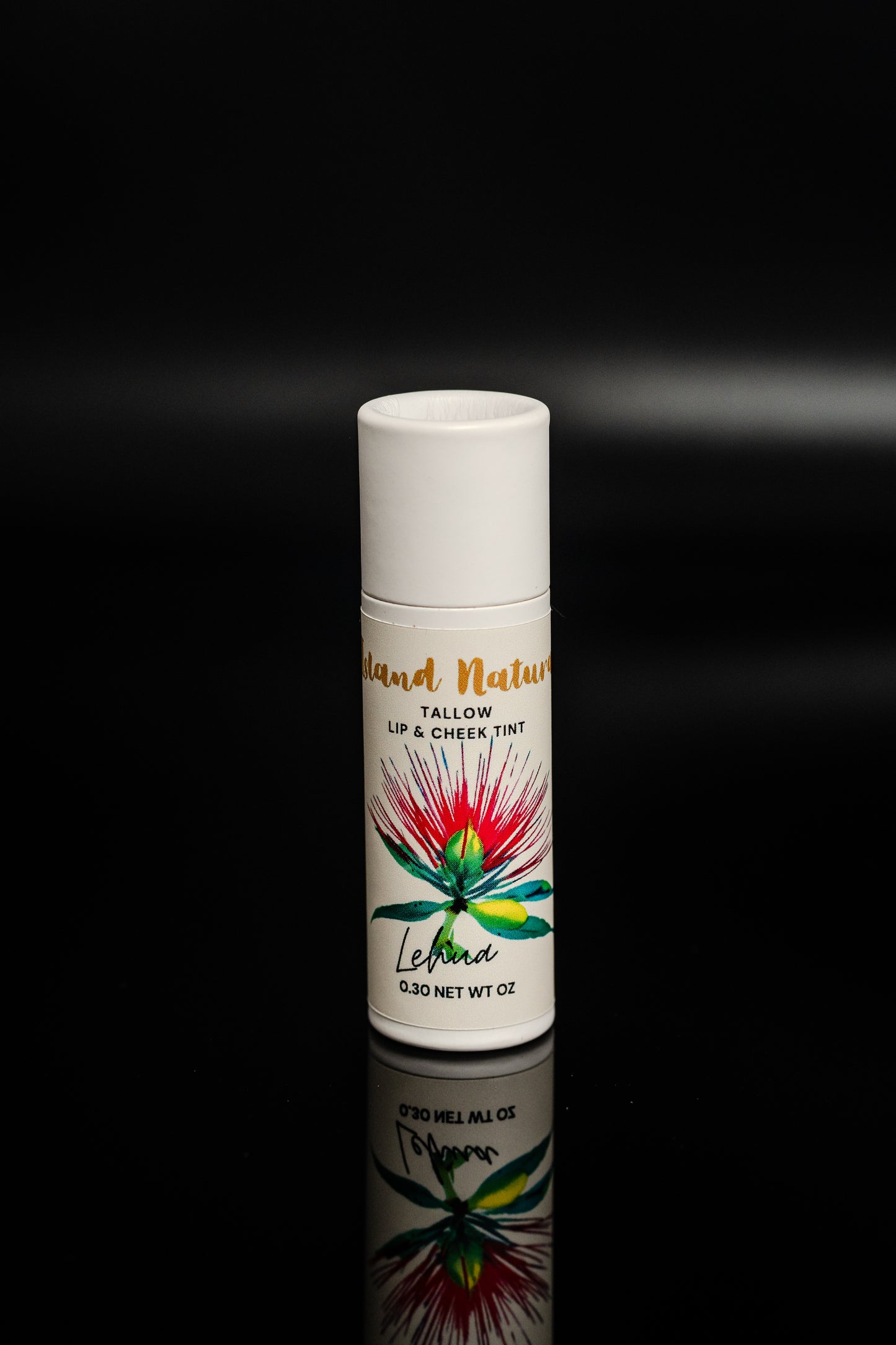 Island Natural Skincare tallow lip and cheek tint with colorful label on a black background