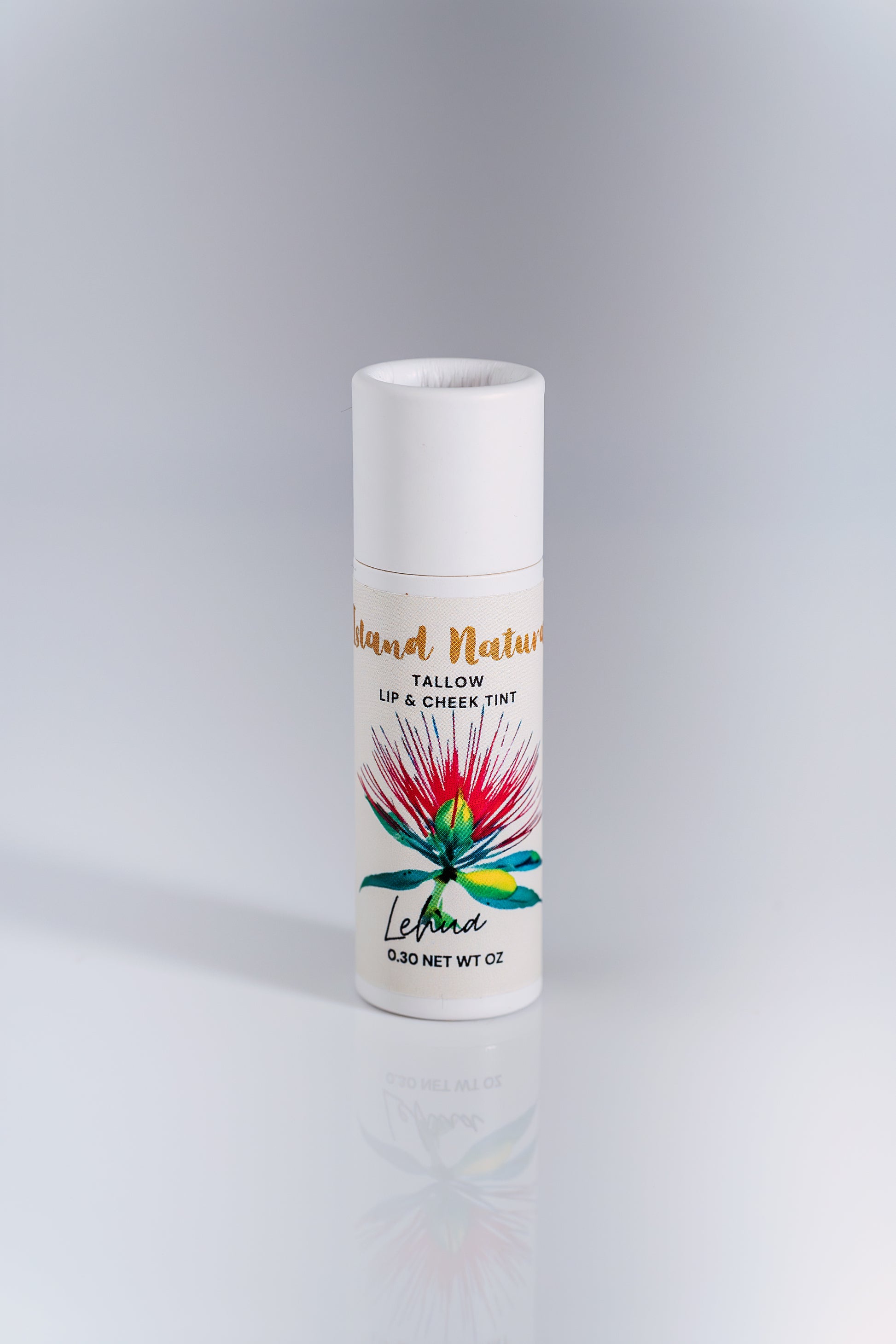 Raspberry red tallow lip and cheek tint tube with colorful label on a gray background by Island Natural Skincare