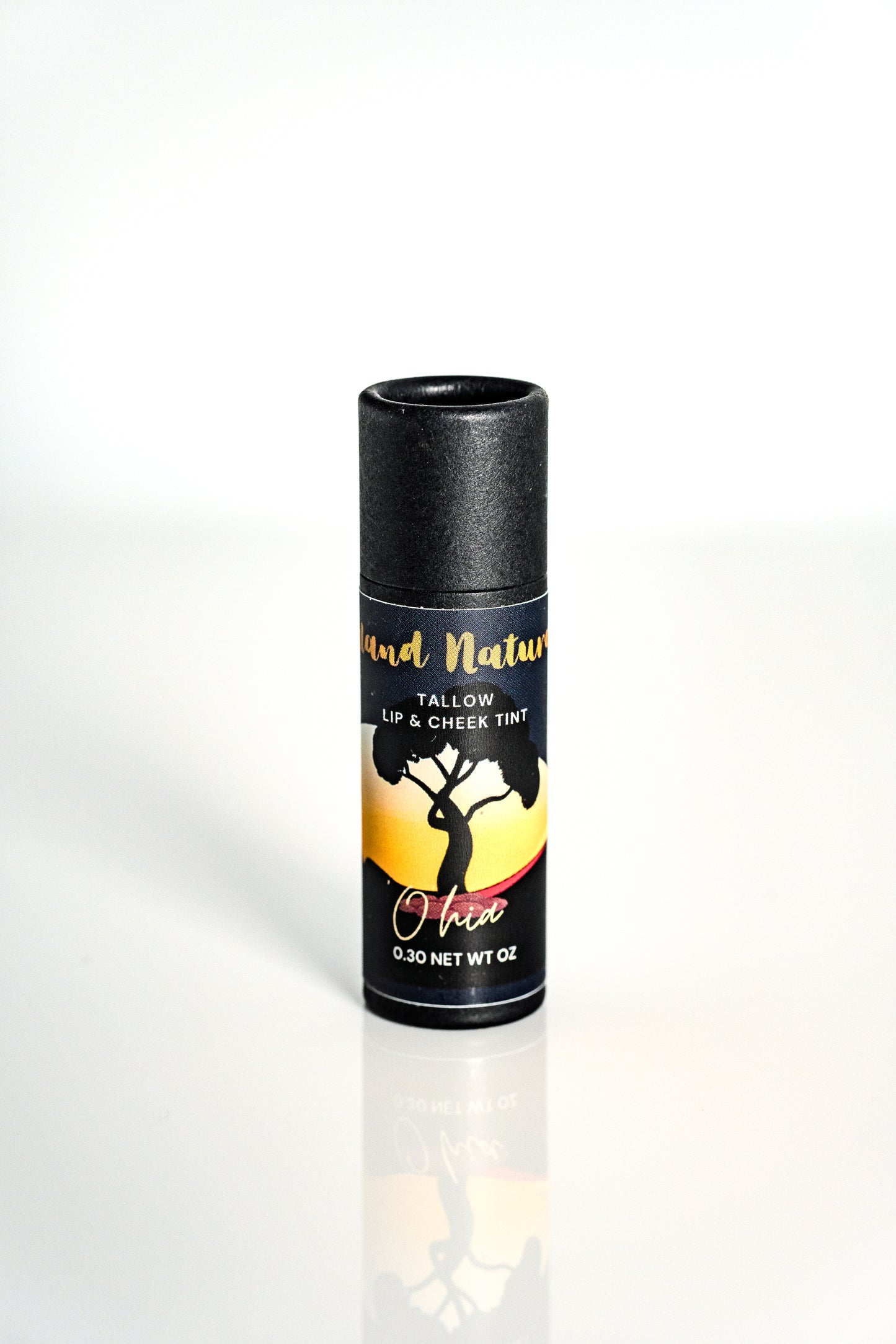 'Ohi'a tinted tallow lip balm with black lid and colorful label on a white background by Island Natural Skincare
